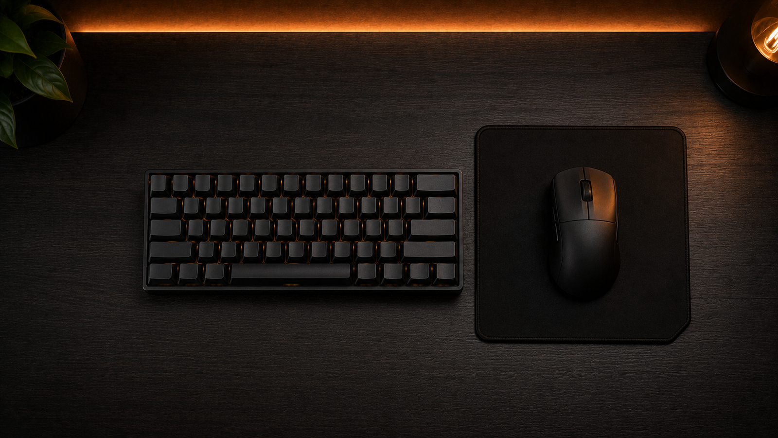 Top down view of a lightweight gaming mouse on a compact mousepad next to a 60% keyboard.